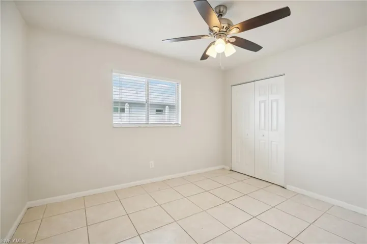 Empty room featuring light tile patterned floors and ceiling fan