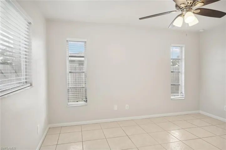 Unfurnished room featuring light tile patterned floors and ceiling fan