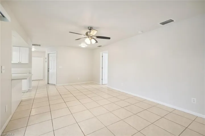 Tiled spare room featuring ceiling fan