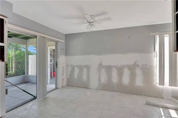 Unfurnished room with ceiling fan and light tile flooring