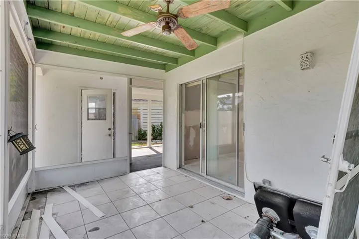 Unfurnished sunroom with beam ceiling, wood ceiling, and ceiling fan