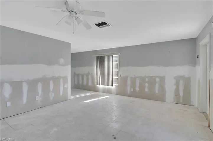 Tiled empty room featuring ceiling fan