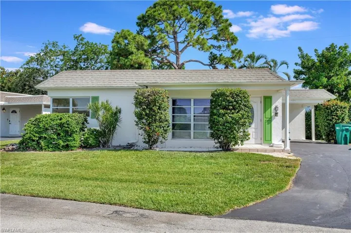 View of front of home featuring a carport and a front yard