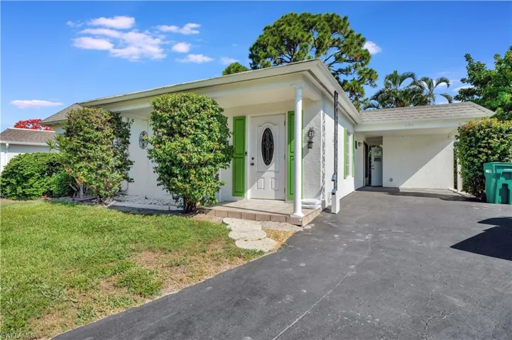 View of front of house with a carport and a front yard