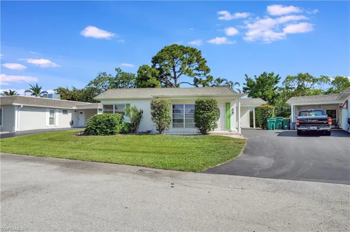 Ranch-style home with a garage, a carport, and a front yard
