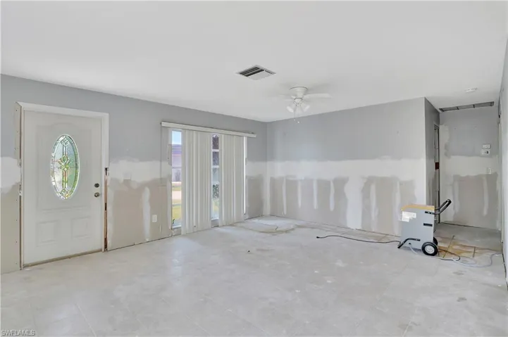 Entrance foyer with ceiling fan and light tile flooring