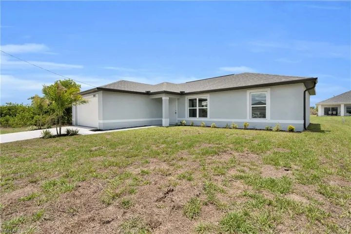 Contemporary single-story residence featuring a light gray stucco exterior, dark shingle roof, and white trim