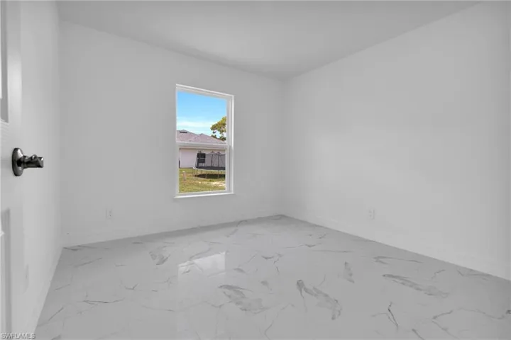 Interior room featuring white walls, white baseboards, and a single window with white trim