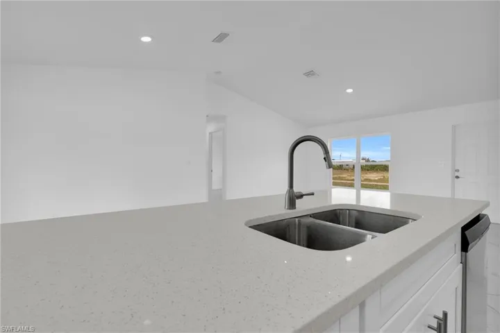 Kitchen island featuring a dual basin stainless steel sink with a matte black gooseneck faucet