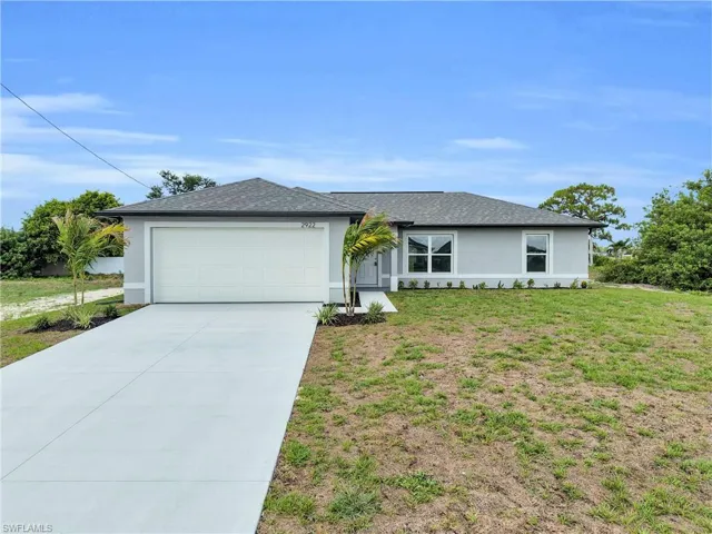 Single-story residence featuring a two-car garage, light gray exterior stucco, and a dark gray shingle roof