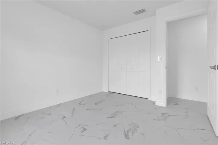 Light-filled interior space featuring white walls and a wide baseboard trim