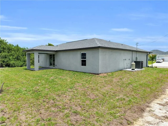 Single-story residence featuring a stucco exterior, covered patio, and a dark shingle roof