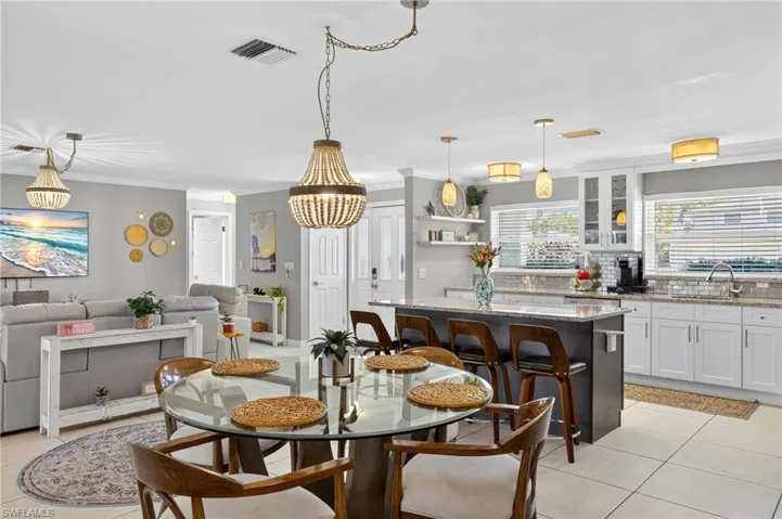 Dining area with light tile patterned floors and ornamental molding