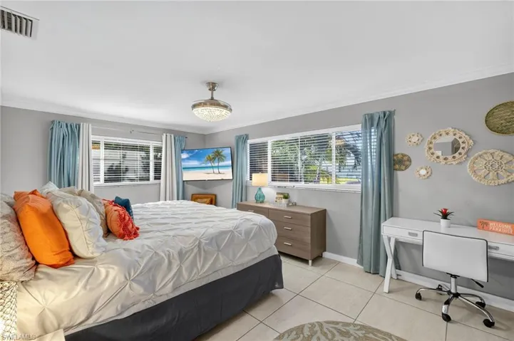 Bedroom featuring crown molding and light tile patterned floors