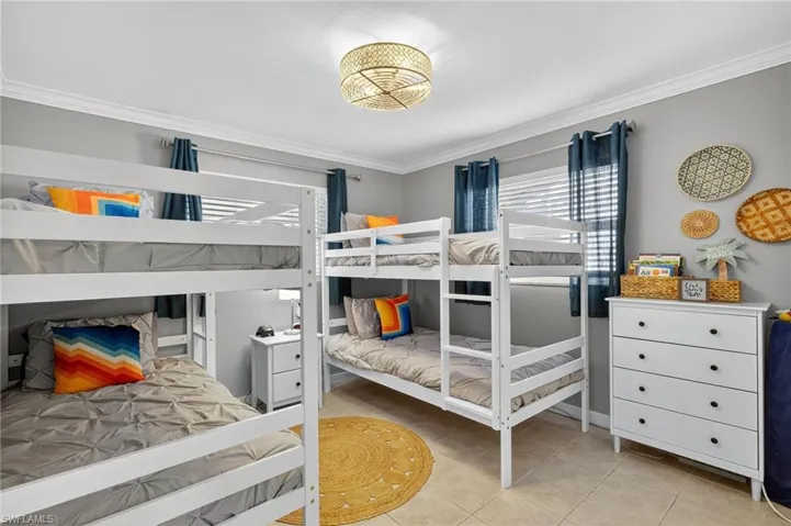 Bedroom featuring crown molding and light tile patterned floors