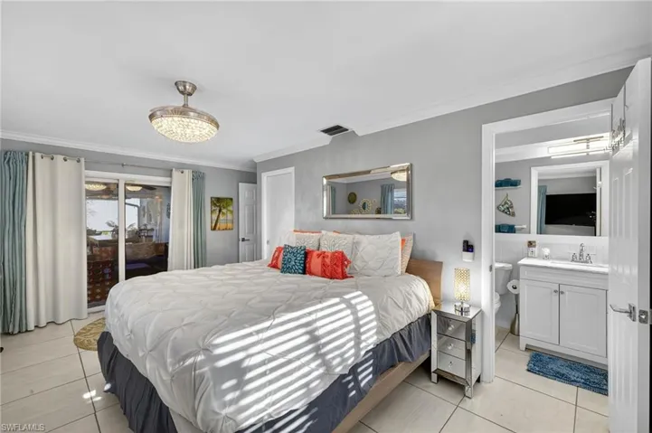Bedroom with access to exterior, crown molding, and light tile patterned floors