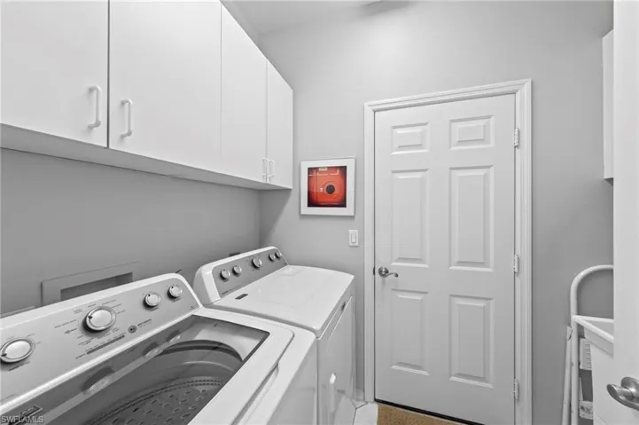 Washroom featuring cabinet space and washer and clothes dryer