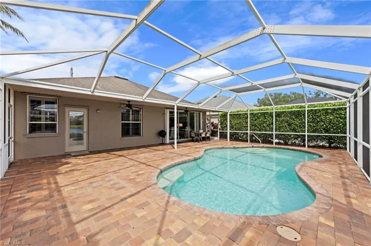 Outdoor pool featuring a sunroom, ceiling fan, a patio area, and glass enclosure