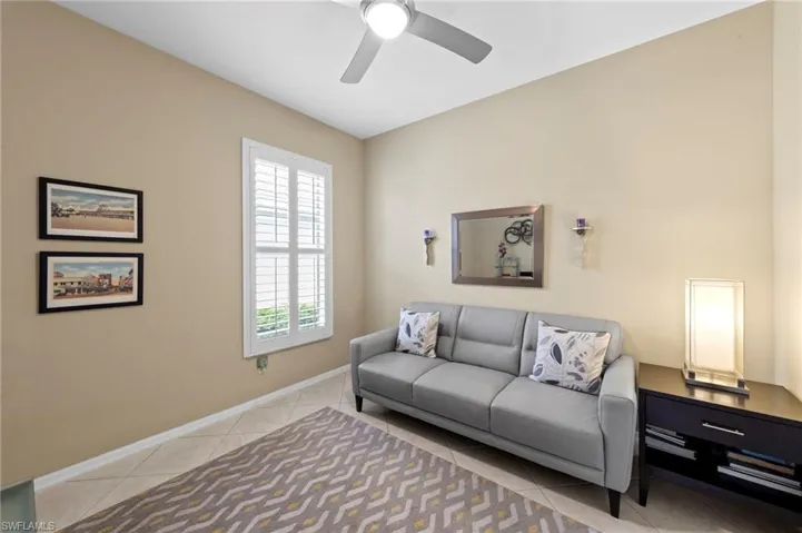 Living room featuring light tile patterned flooring and a ceiling fan