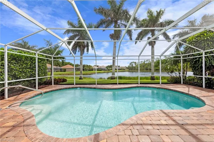 Outdoor pool featuring a water view, a sunroom, a patio area, and a lanai