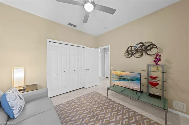 Sitting room with light tile patterned floors and a ceiling fan