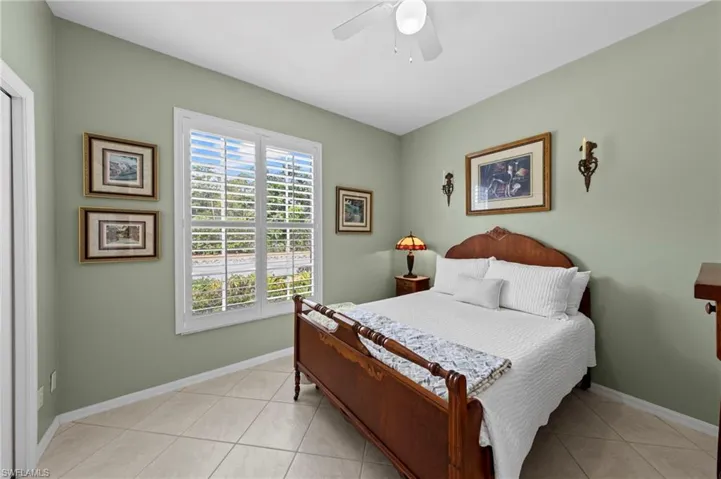 Bedroom with light tile patterned floors and ceiling fan