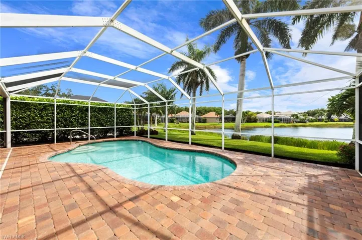 Swimming pool with a sunroom, a patio, a water view, a lanai, and a residential view