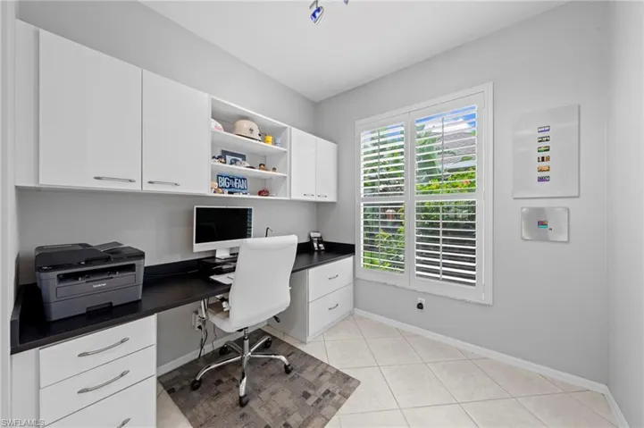 Office featuring built in desk and light tile patterned floors