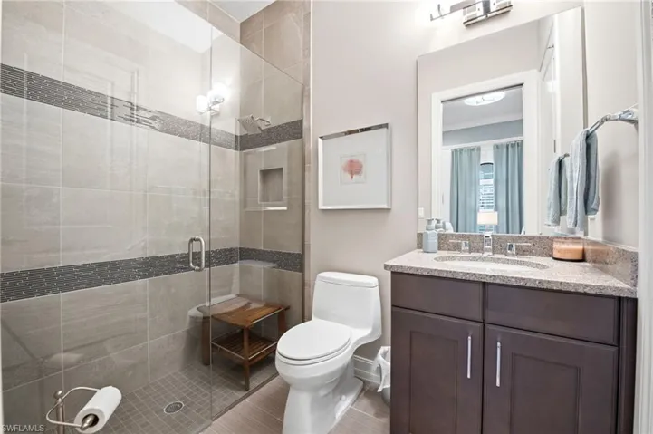 Bathroom featuring a vanity with stone-finish countertop, undermount sink, and dark cabinetry