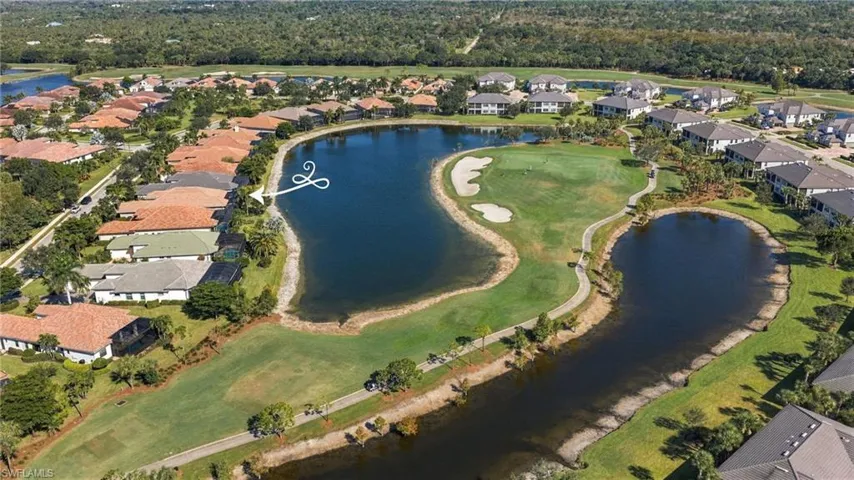 Aerial perspective featuring a waterfront setting, expansive golf course grounds, paved cart paths, and established landscaping