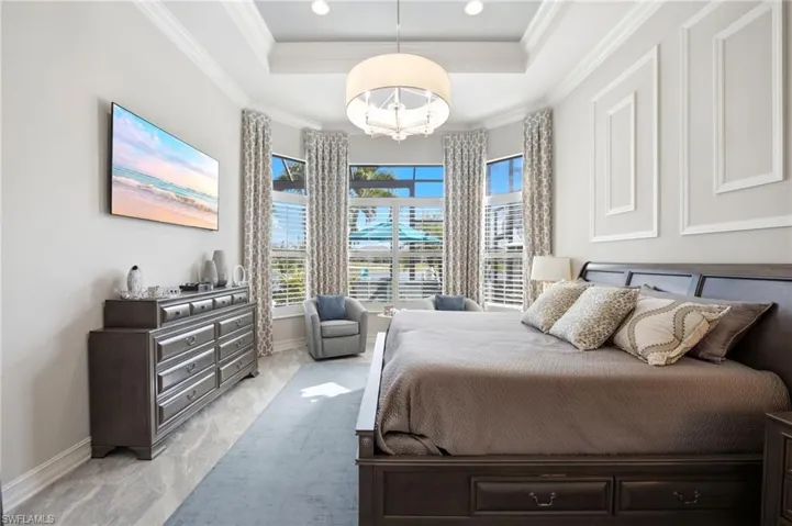 Tray ceiling featuring recessed lighting, central drum chandelier, bay windows, and wall molding accents
