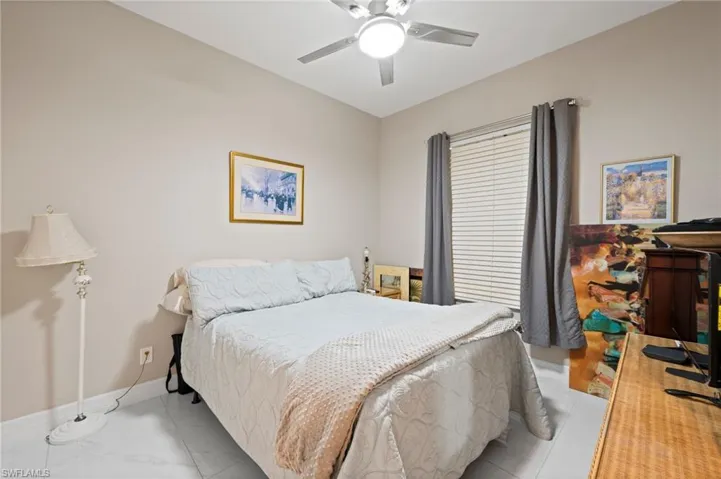 Tiled bedroom featuring ceiling fan