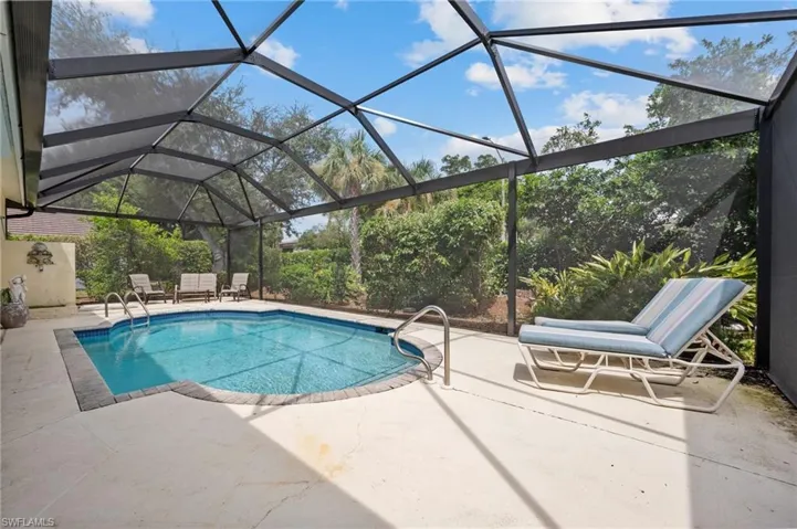 View of pool with a lanai and a patio