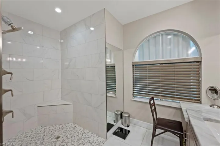 Bathroom featuring a tile shower and vanity