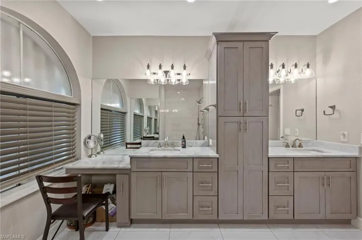 Bathroom featuring tile patterned floors, a tile shower, and vanity