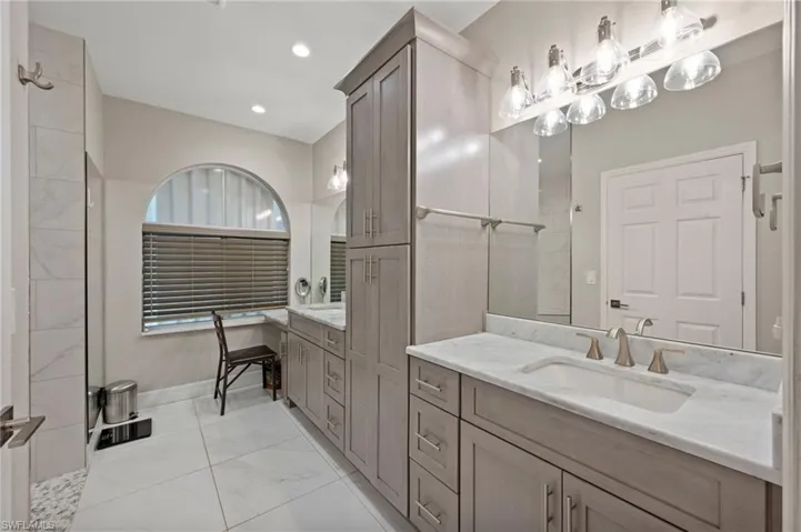 Bathroom with tile patterned flooring, vanity, and tiled shower