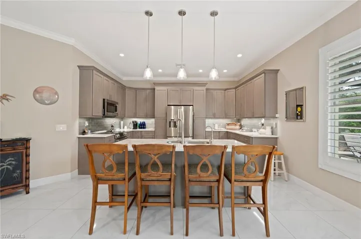 Kitchen with tasteful backsplash, light tile patterned flooring, an island with sink, and stainless steel appliances