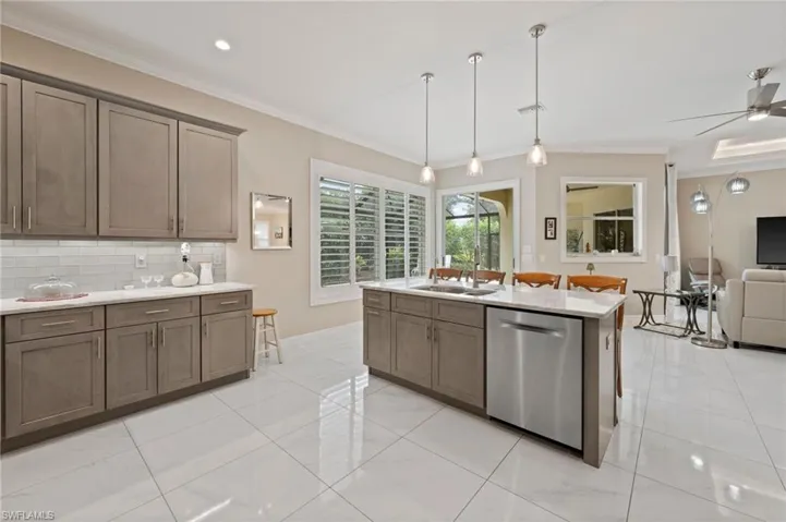Kitchen with light tile patterned flooring, backsplash, a kitchen island, dishwasher, and ceiling fan