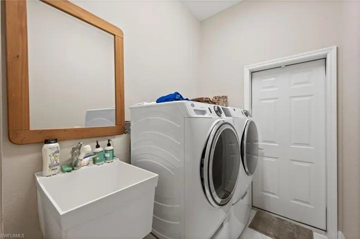 Laundry area featuring independent washer and dryer and sink