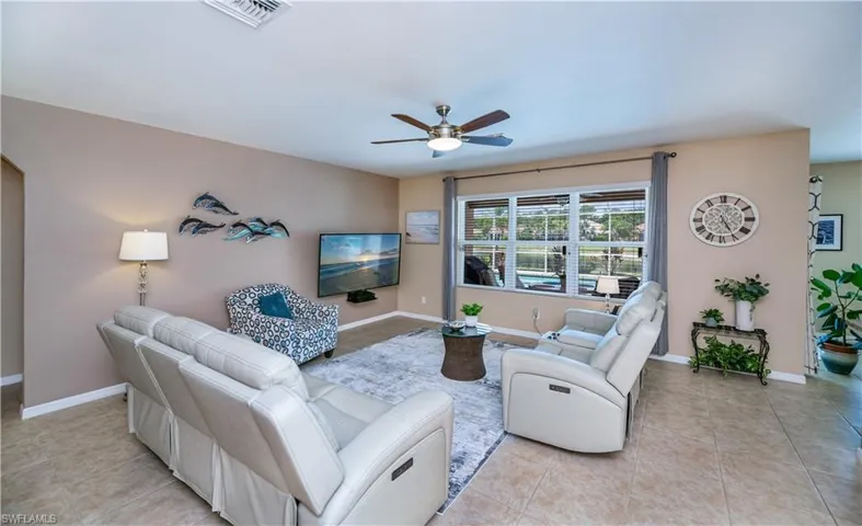 Living room featuring a ceiling fan and light tile patterned floors