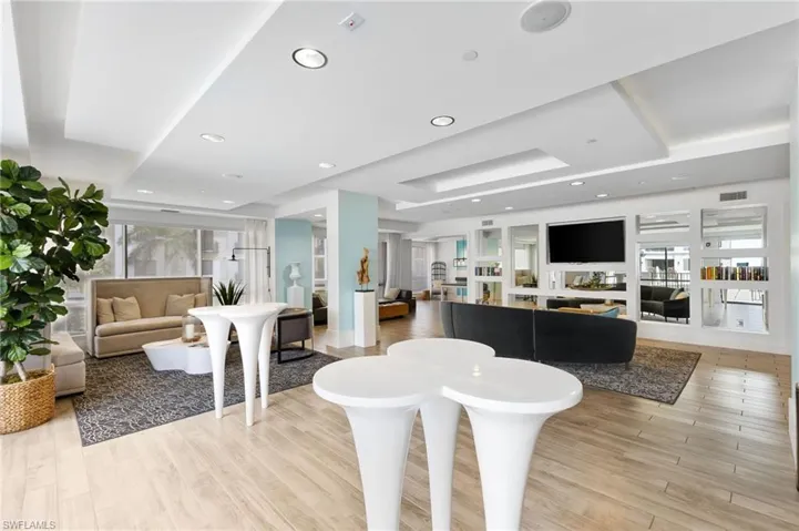 Living room featuring a tray ceiling, light wood-style flooring, and recessed lighting