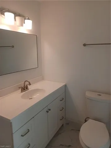 Half bathroom featuring vanity and marble finish floors