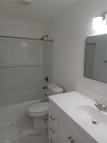 Bathroom with vanity, tub / shower combination, and marble finish floors