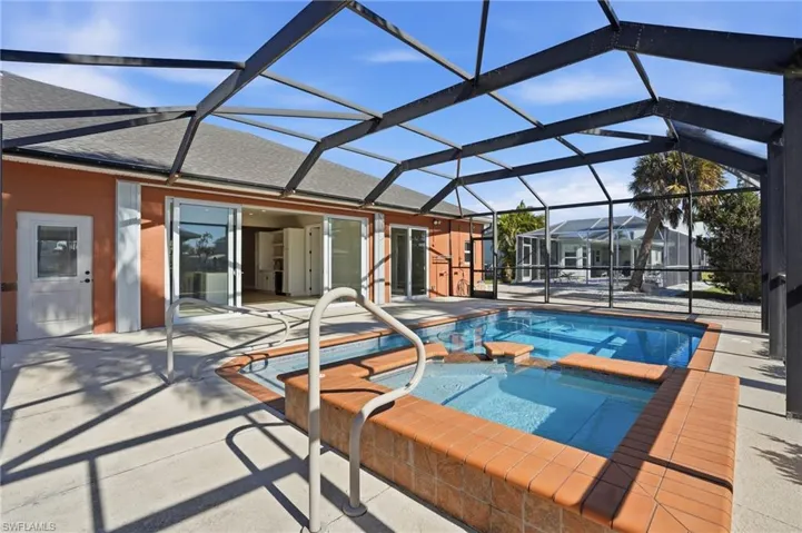Combined pool / hot tub featuring a lanai, a patio, and a sunroom - Virtually Edited Image