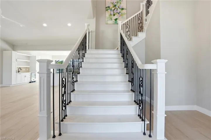 Stairs featuring wood finished floors, beverage cooler, and recessed lighting - Virtually Edited Image