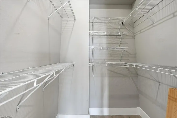 Walk in closet with wood finished floors - Virtually Edited Image