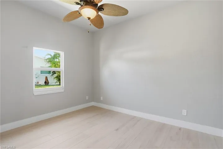 Unfurnished room with light wood finished floors and ceiling fan - Virtually Edited Image