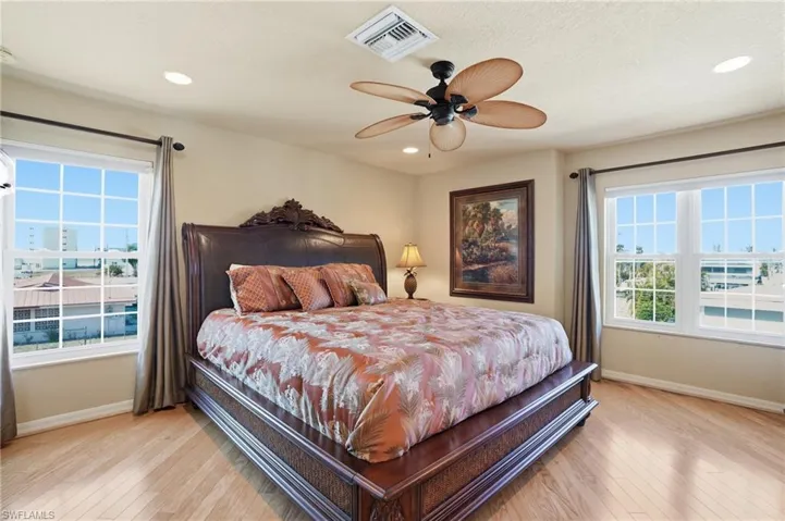 Bedroom featuring light wood finished floors, ceiling fan, and recessed lighting - Virtually Edited Image
