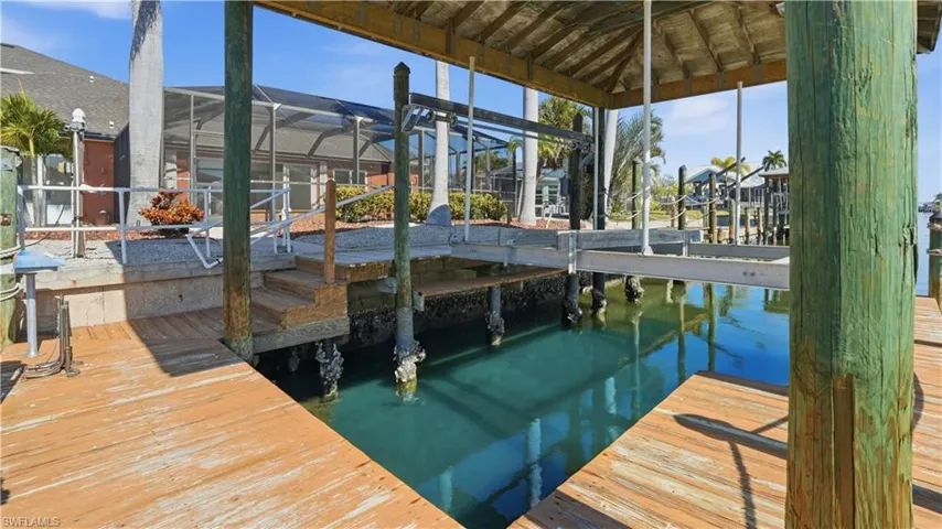 Dock area with glass enclosure, a sunroom, and a water view - Virtually Edited Image