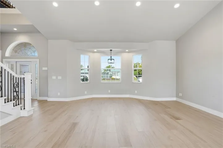 Unfurnished living room featuring light wood finished floors and recessed lighting - Virtually Edited Image